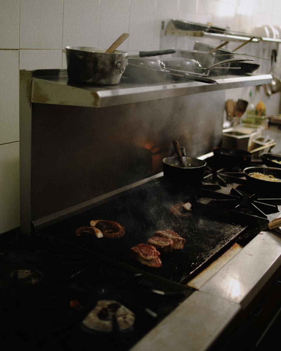 La plancha encendida — carnes a fuego en cocina de Ophelia